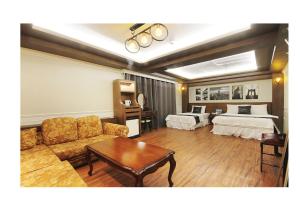a living room with a couch and a bed at Prince hotel in Goseong