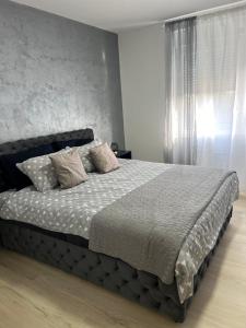 ein Schlafzimmer mit einem großen Bett mit Kissen darauf in der Unterkunft Apartman Central Lux A&D in Bečej