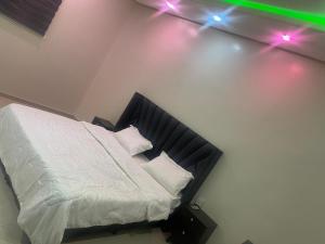 شقه غرفه وصاله مريحه في الرياض: غرفة نوم مع سرير مع أضواء على الحائط