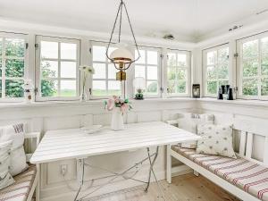 comedor blanco con mesa y ventanas en 4 person holiday home in T nder, en Tønder
