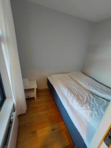 a small bedroom with a bed and a wooden floor at Hamn i Senja in Hamn