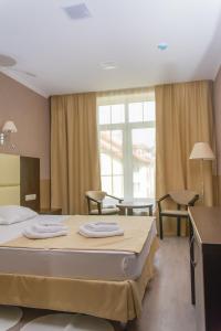 1 dormitorio con 1 cama con 2 toallas en Eliza Inn, en Zelenogradsk