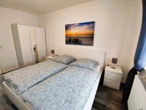 a bedroom with two beds and a painting on the wall at Ferienwohnung Heide 1 in Walsrode