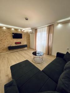 ein Wohnzimmer mit einem Sofa und einem Tisch in der Unterkunft Apartman Central Lux A&D in Bečej