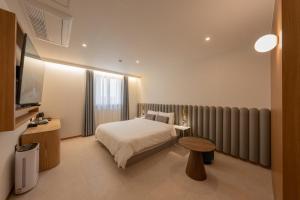 a bedroom with a bed and a radiator at H-avenue Hotel Munhyeon in Busan