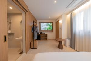 a hotel room with a television and a bathroom at H-avenue Hotel Munhyeon in Busan