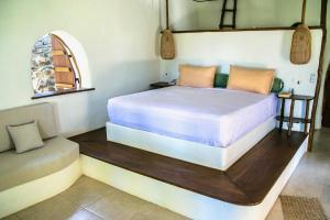 1 dormitorio con 1 cama y 1 silla en Beach-Front Sumbawa Surf House en Lemonga