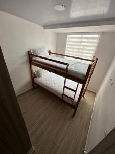 1 dormitorio con 2 literas y ventana en Ibague cowork, en Ibagué