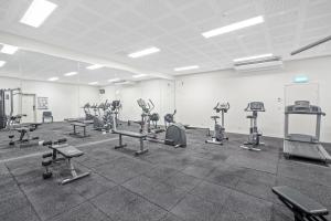 una palestra con file di attrezzi ginnici in una stanza di Belle Escpaes Drift Beachfront Resort Suite 3401 a Palm Cove