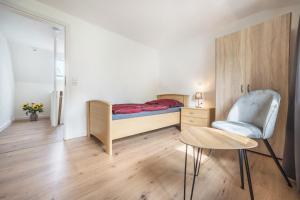 ein Schlafzimmer mit einem Bett, einem Stuhl und einem Tisch in der Unterkunft Ferienhaus Inge in Oldenburg