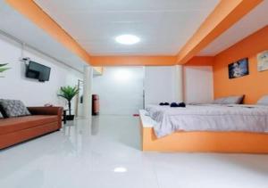 a bedroom with a large bed and a couch at PRAKAI RESORT in Ban Don Klang
