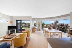 un soggiorno con tavolo e sedie e una sala da pranzo di Serenity at Smiths Beach a Smiths Beach