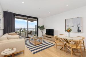 a living room with a table and a couch at Sea View 2BR w Best Rooftop Pool in Melb! in Melbourne