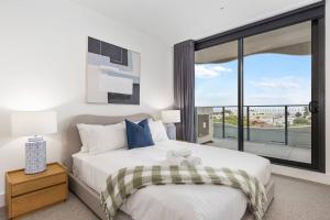 a bedroom with a large bed and a large window at Sea View 2BR w Best Rooftop Pool in Melb! in Melbourne