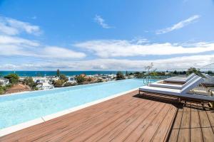 a swimming pool on a deck with a view of the ocean at Sea View 2BR w Best Rooftop Pool in Melb! in Melbourne
