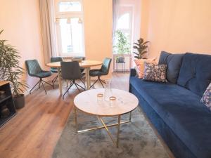 salon z niebieską kanapą i stołem w obiekcie Ferienwohnung "Fünf Freunde" w mieście Erfurt