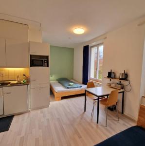 een kamer met een keuken en een kleine kamer met een bed bij Casa Maria Apartments in Solothurn