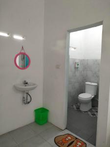 y baño con aseo y lavamanos. en Kempu Tigan, en Berastagi
