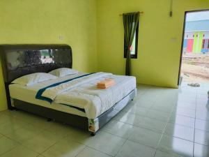 1 dormitorio con 1 cama en una habitación verde en Kempu Tigan, en Berastagi