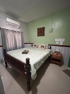um quarto com uma cama com uma colcha branca e uma mesa de cabeceira em Baan Are Gong Riverside Homestay em Phra Nakhon Si Ayutthaya