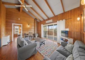 un soggiorno con un divano e un tavolo di North Lodge Highland Cottage a Pokolbin