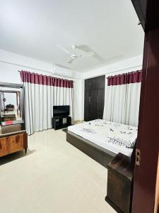 a bedroom with a large bed and a television at Astachal Homestay in Guwahati