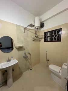 a bathroom with a sink and a toilet and a mirror at Astachal Homestay in Guwahati +15 photos