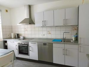 una cocina con armarios blancos y fregadero en Ferienhaus Heide, en Bad Fallingbostel