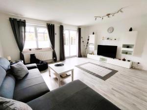 ein Wohnzimmer mit einem Sofa und einem TV in der Unterkunft Ferienhaus Heide in Bad Fallingbostel