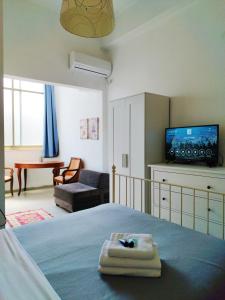 a bedroom with a bed with a television and a living room at Eden Hotel in Haifa