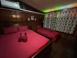 a pair of shoes sitting on a bed in a room at Baan Are Gong Riverside Homestay in Phra Nakhon Si Ayutthaya