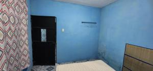 a room with a bed and a blue wall at Jaguar long-stay Guest House in Ciudad Vieja in Ciudad Vieja