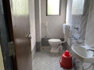 a bathroom with a toilet and a sink at Hotel Sai viraj palace in Shirdi