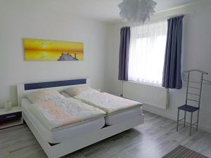 1 dormitorio con cama blanca y ventana en Ferienhaus Heide, en Bad Fallingbostel