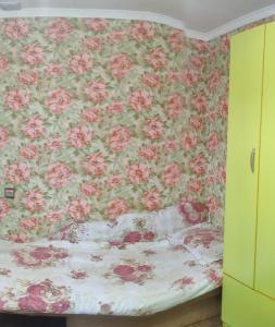 um quarto com um papel de parede florido e uma cama em 锦江LoveMyHome em Almaty