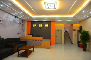 un vestíbulo de oficina con una zona de espera y una escalera en Hongge Hotel - Harbin Taiping Airport en Harbin