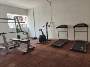 a gym with three treadying machines in a room at 소문난게스트하우스 in Kanchipuram