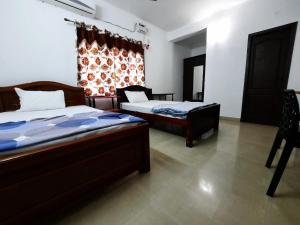 1 dormitorio con 2 camas y ventana en 소문난게스트하우스, en Kanchipuram