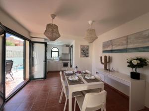 kuchnia i jadalnia ze stołem i krzesłami w obiekcie Villa Olympia Lovely, Close to Town and Beaches with Private Pool & Fast WiFi w Corralejo