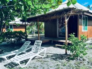 two chairs and a table and a house at MONITA VILLA Rangiroa in Tiputa +35 photos