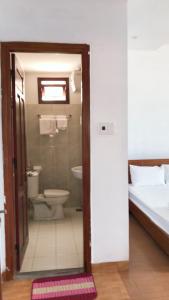 a bathroom with a shower and a toilet and a bed at Motel Minh Thảo in Da Nang