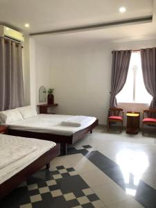 a bedroom with two beds and two chairs in it at Motel Minh Thảo in Danang