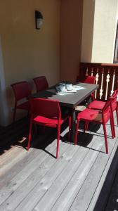 a dining room table with four red chairs around it at Wald Residence in Bad Kleinkirchheim