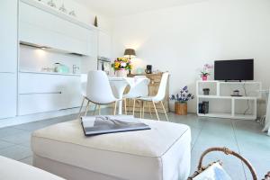 a white living room with a table and chairs at Appartamento Amaryllis, incantevole con piscina in Salò