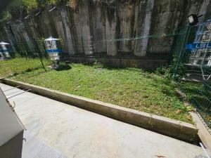 un giardino con recinzione e gabbia per uccelli di World Peace a Kampong Bantun