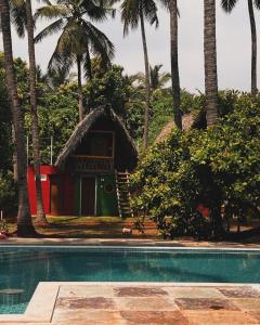 un complejo con piscina y palmeras en Nature Zone Resort, en Pondicherry
