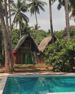 a house with a swimming pool in front of a resort at Nature Zone Resort in Puducherry