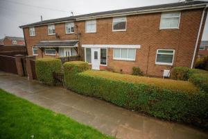 ein Backsteinhaus mit Büschen davor in der Unterkunft OG Stays III- 6bedroom house- sleeps 9persons, Near Nissan & Stadium of Light, free parking in Pallion