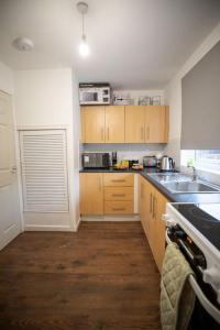 eine Küche mit Holzschränken und einer Spüle in der Unterkunft OG Stays III- 6bedroom house- sleeps 9persons, Near Nissan & Stadium of Light, free parking in Pallion