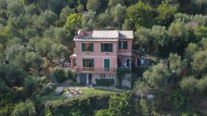 una grande casa rosa su una collina con alberi di B&B Portofino a Portofino